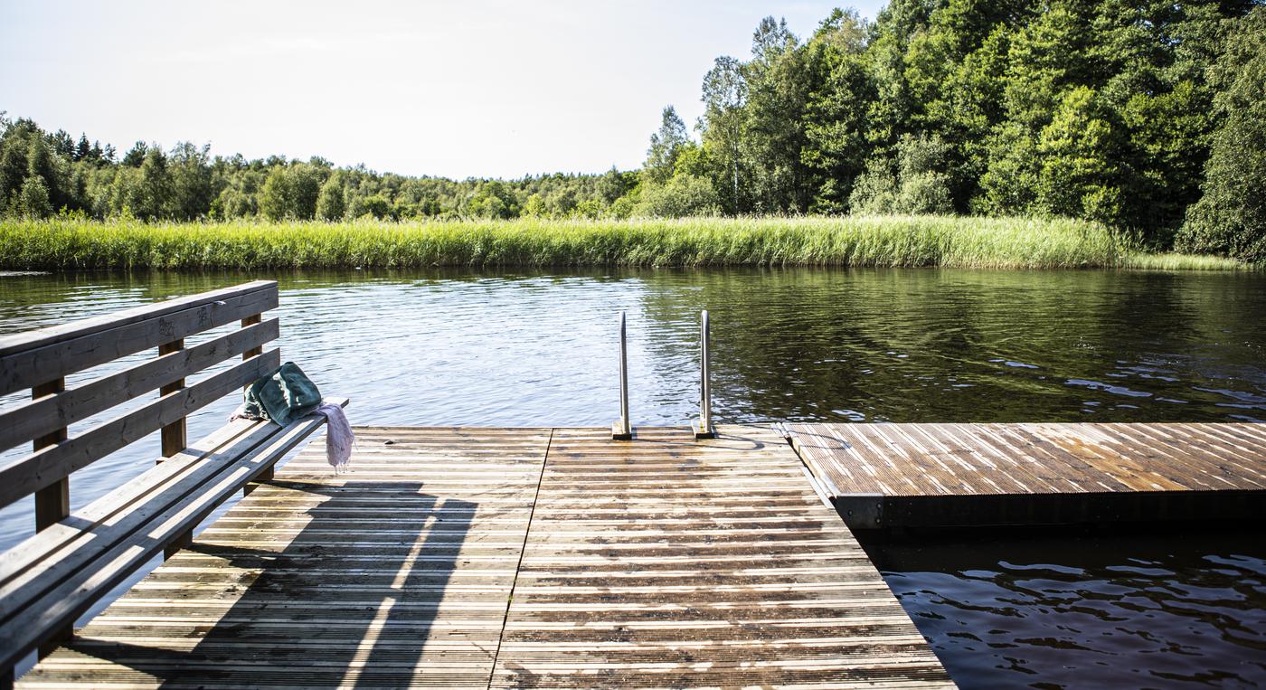 En brygga med en platsbyggd bänk och en stege ner i vattnet