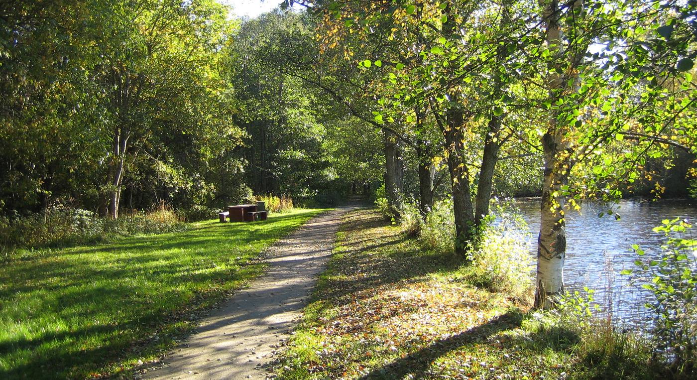 En liten grusväg längs en damm