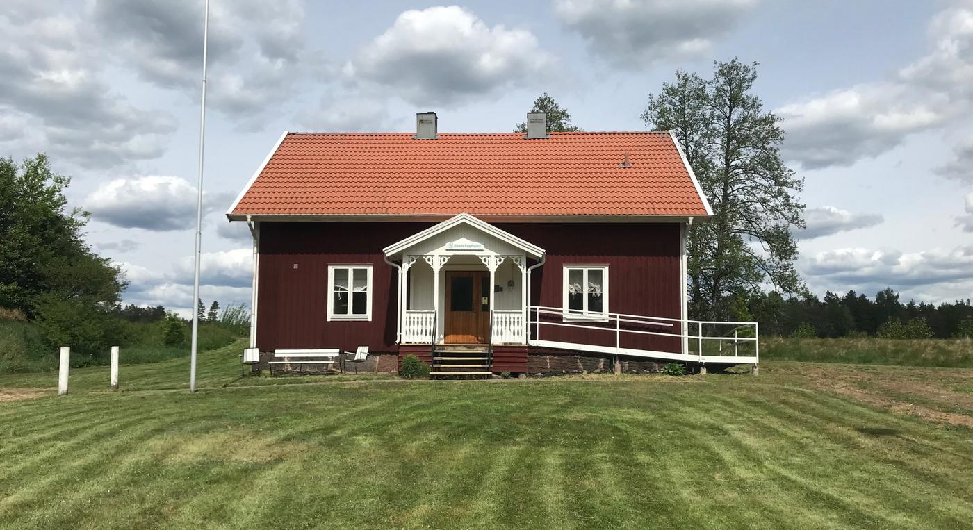 Ett rött hus i lantlig miljö.