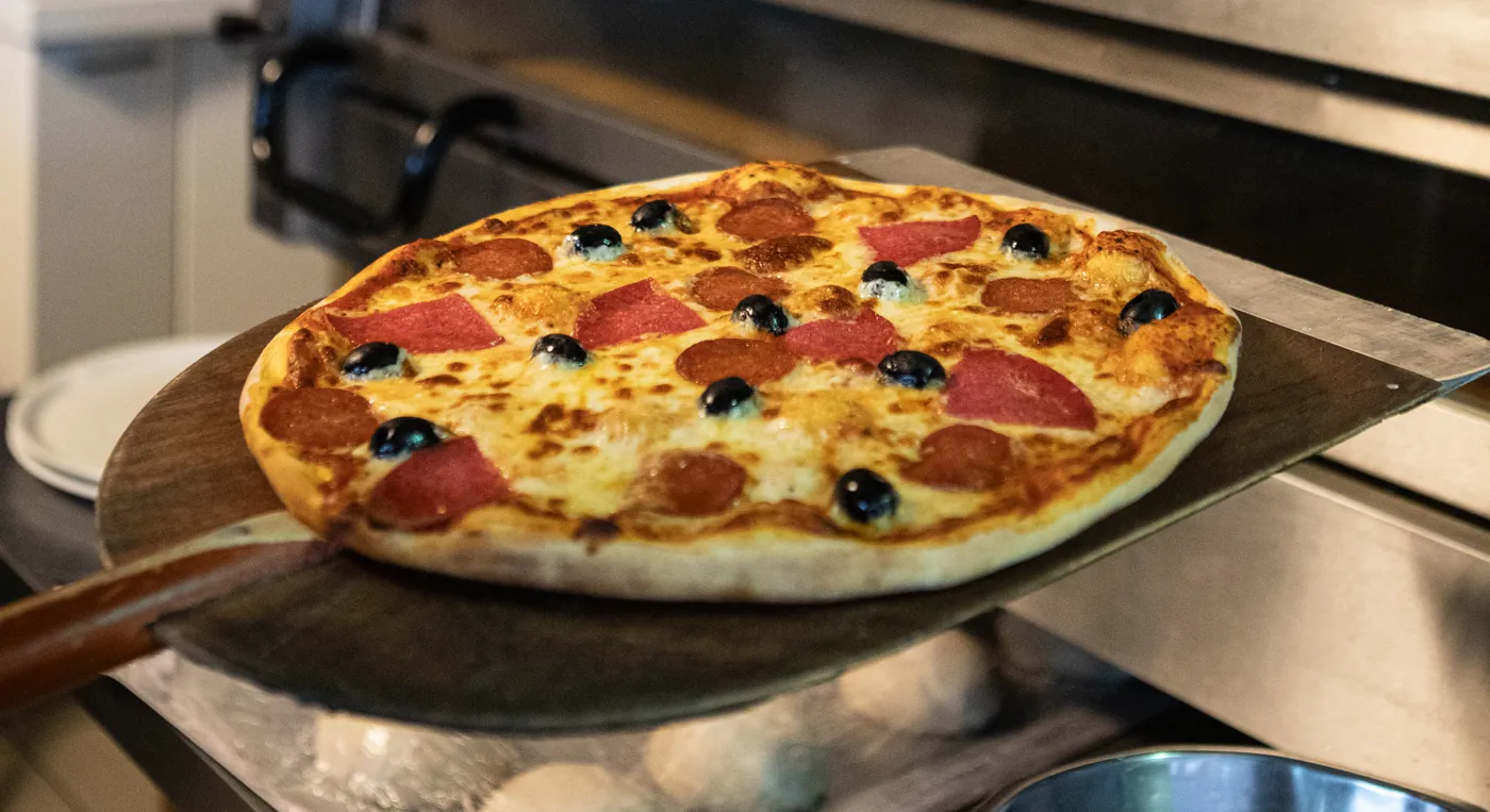 En pizza påväg ut ur ugnen.