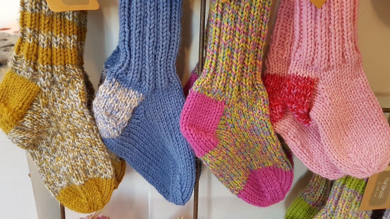 Fyra par stickade sockor i olika färger.
