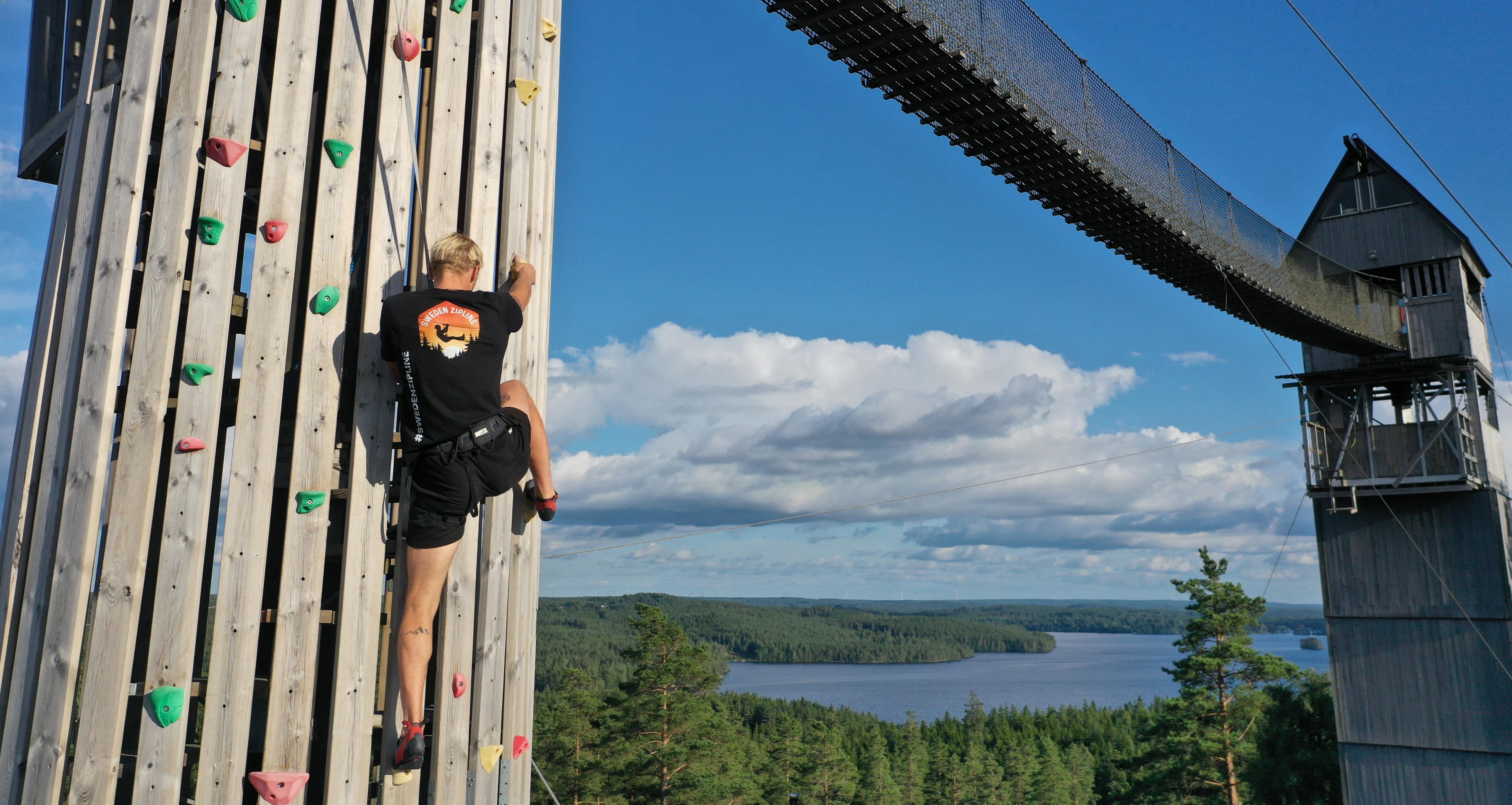 Klättervägg med ustikt över sjö och skog