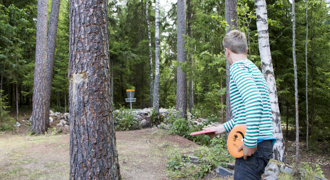 Frisbeekastare siktar för att sätta discen i korgen.