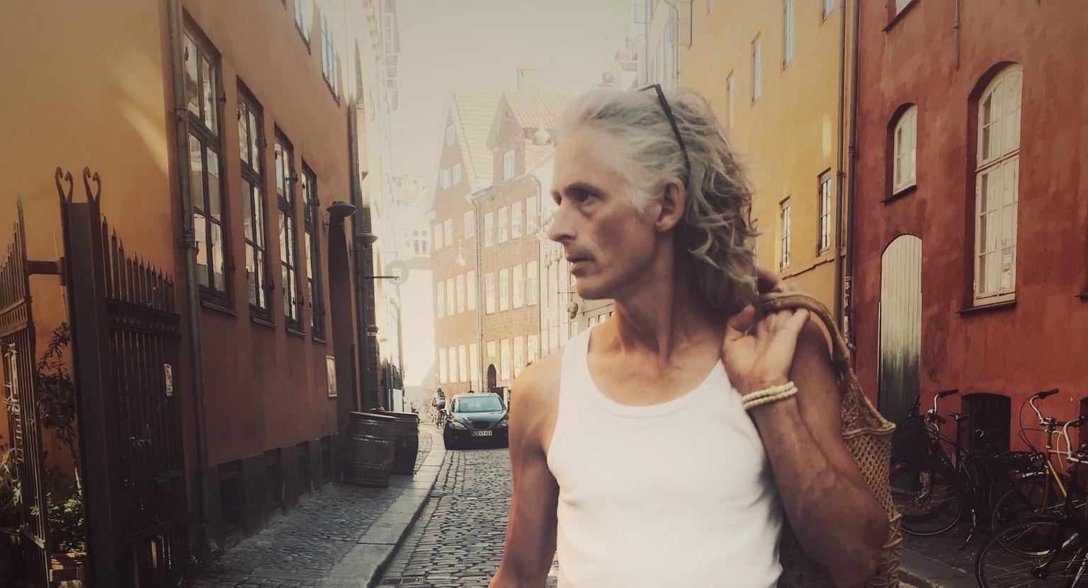 Anders Axelsson går på en kullerstens gata i en gränd.