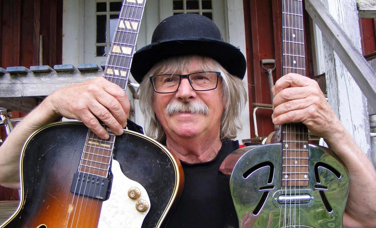 Catfish Charly håller upp två gitarrer
