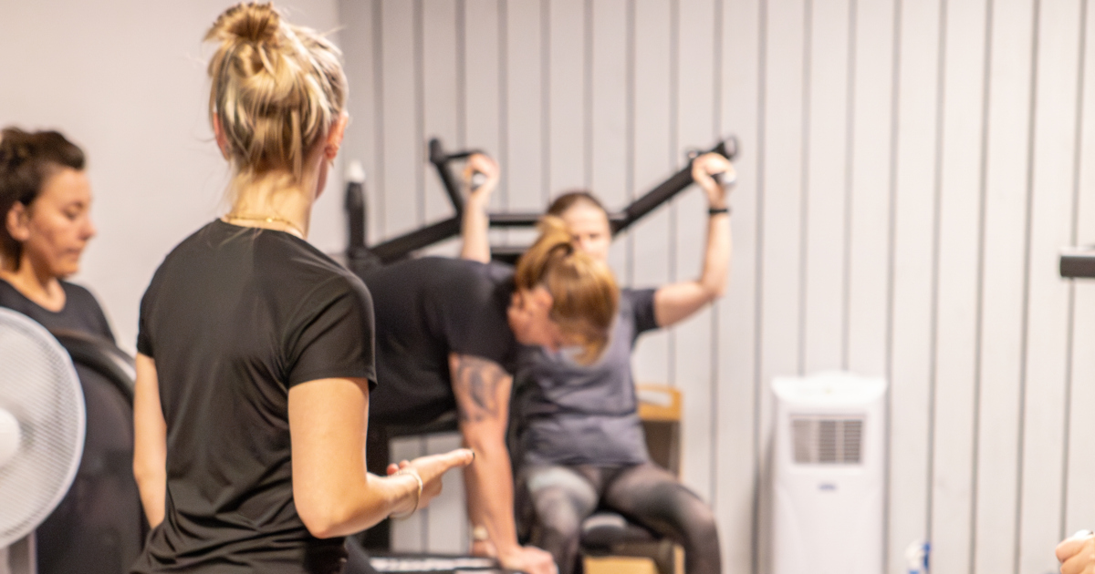 En grupp människor som tränar på ett gym.