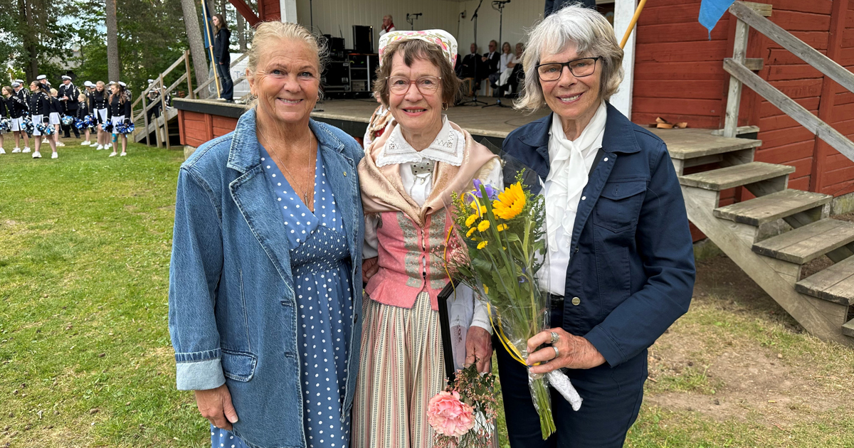 Carina Bardh, Eva Stenkul och Lena Olsson står framför en scen med blommor i händerna.