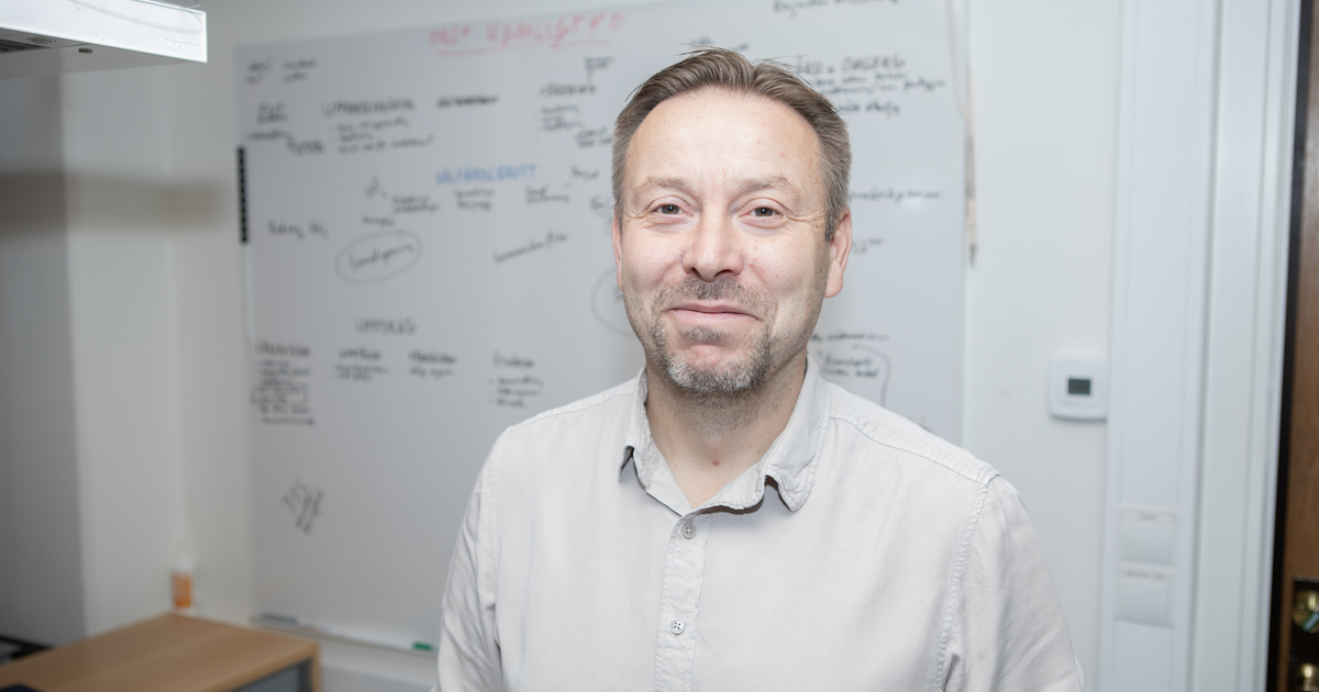 En man står framför en whiteboard fylld med anteckningar