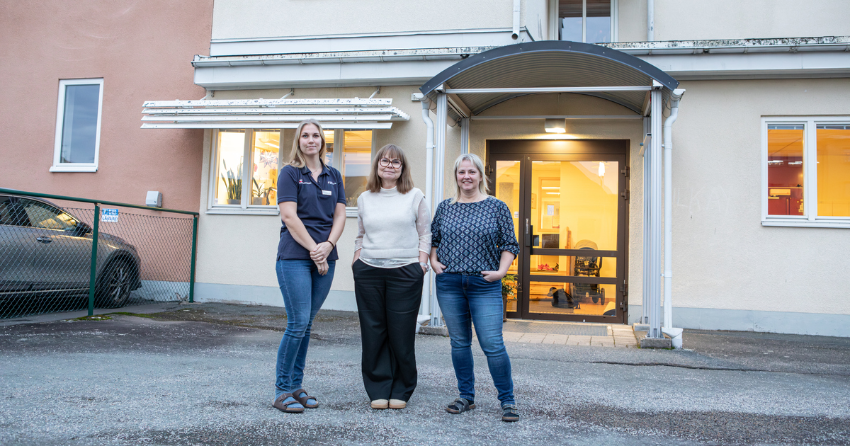 Tre kvinnor står framför en entré till en byggnad.